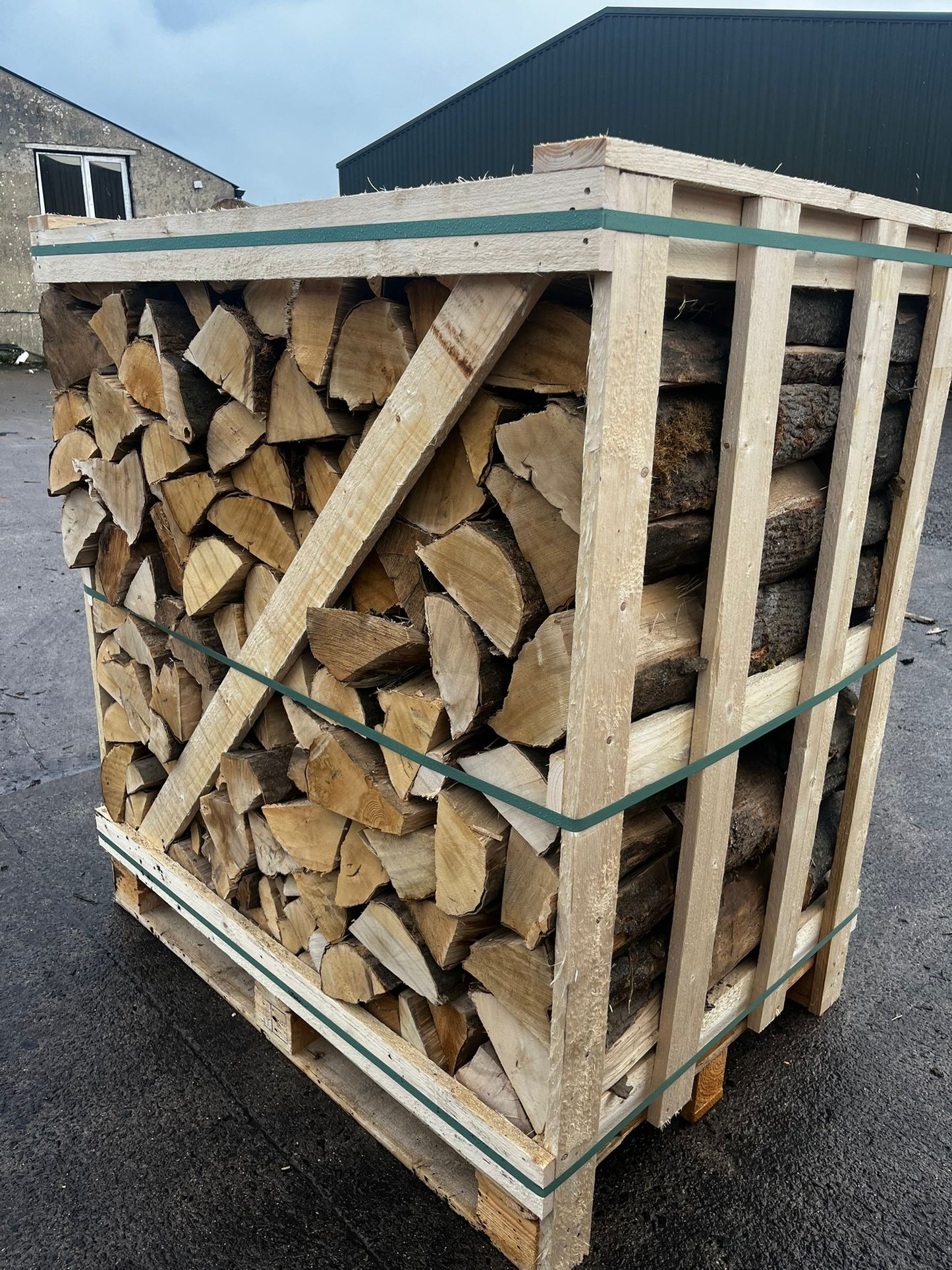 Stack of firewood in a wooden crate on a concrete surface Murphys Direct UK