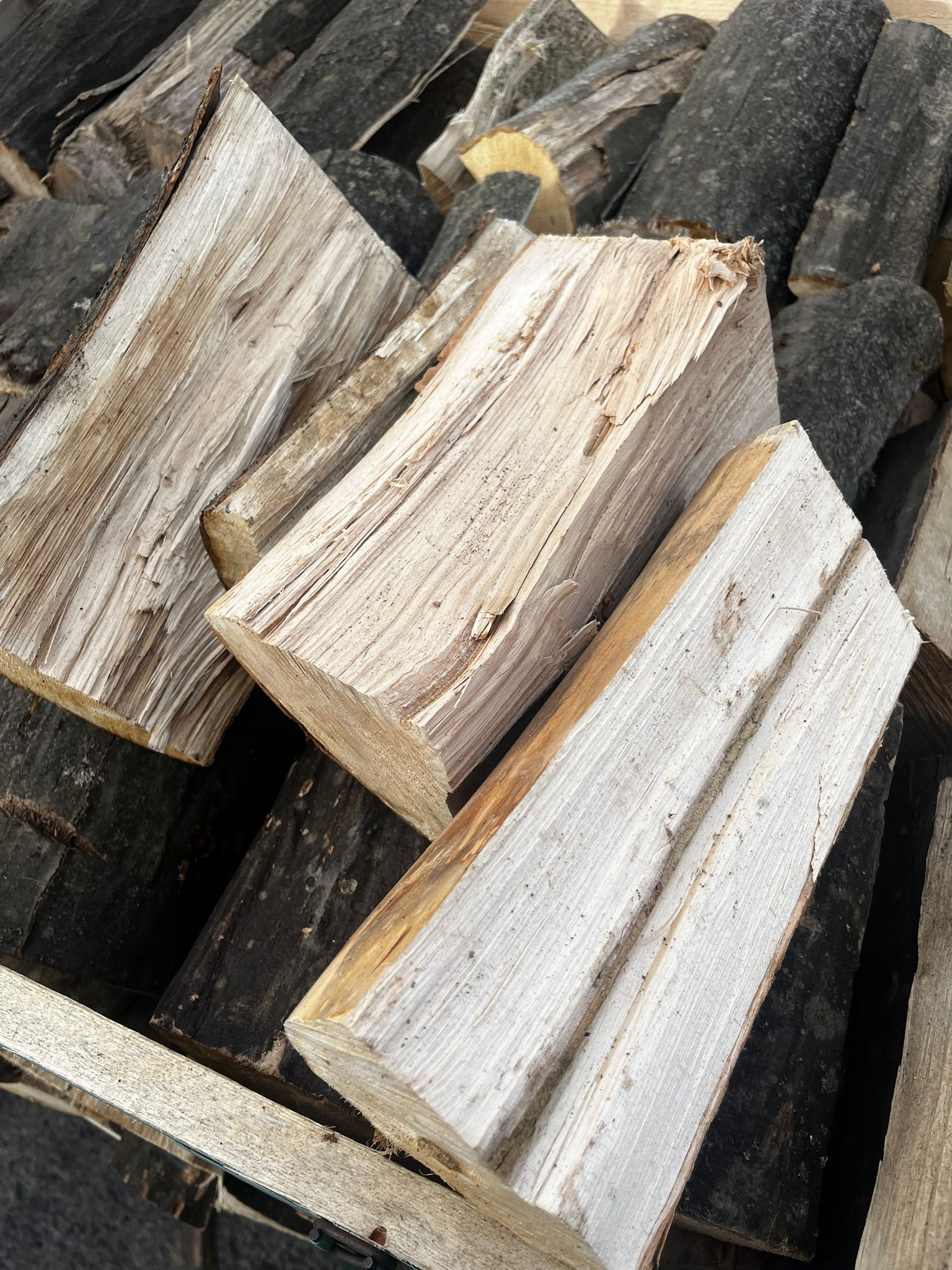 Stack of firewood logs with varying shades of brown Murphys Direct UK